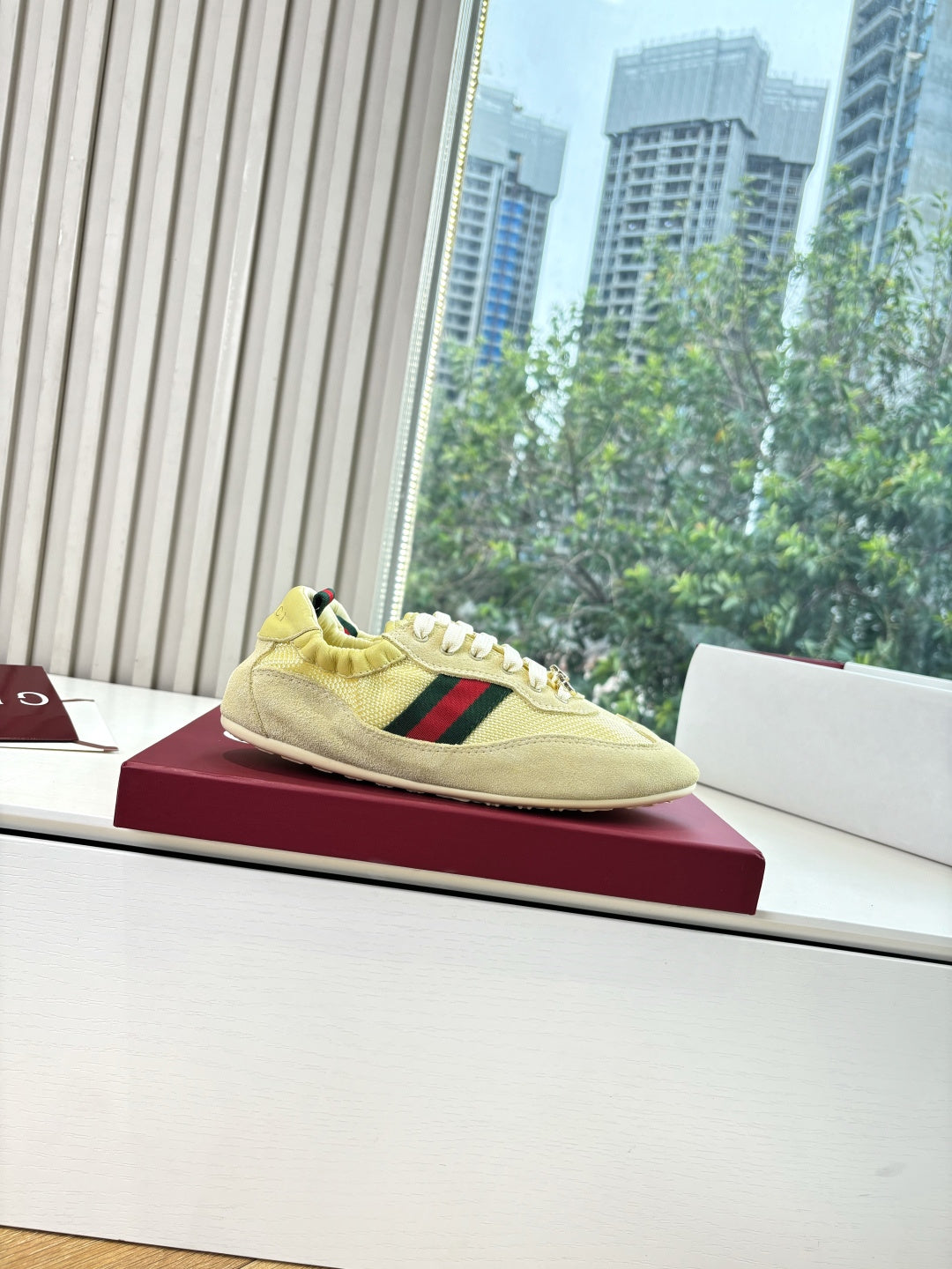 Women's yellow low-top sneakers on display, side profile with Web stripe