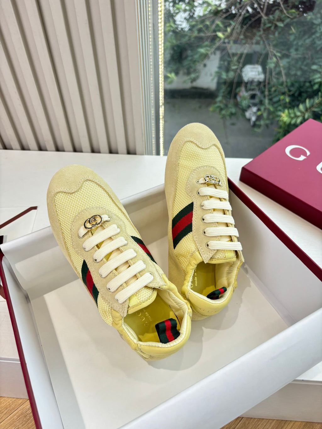 Women's yellow low-top sneakers, side view with Web stripe and gold logo detail