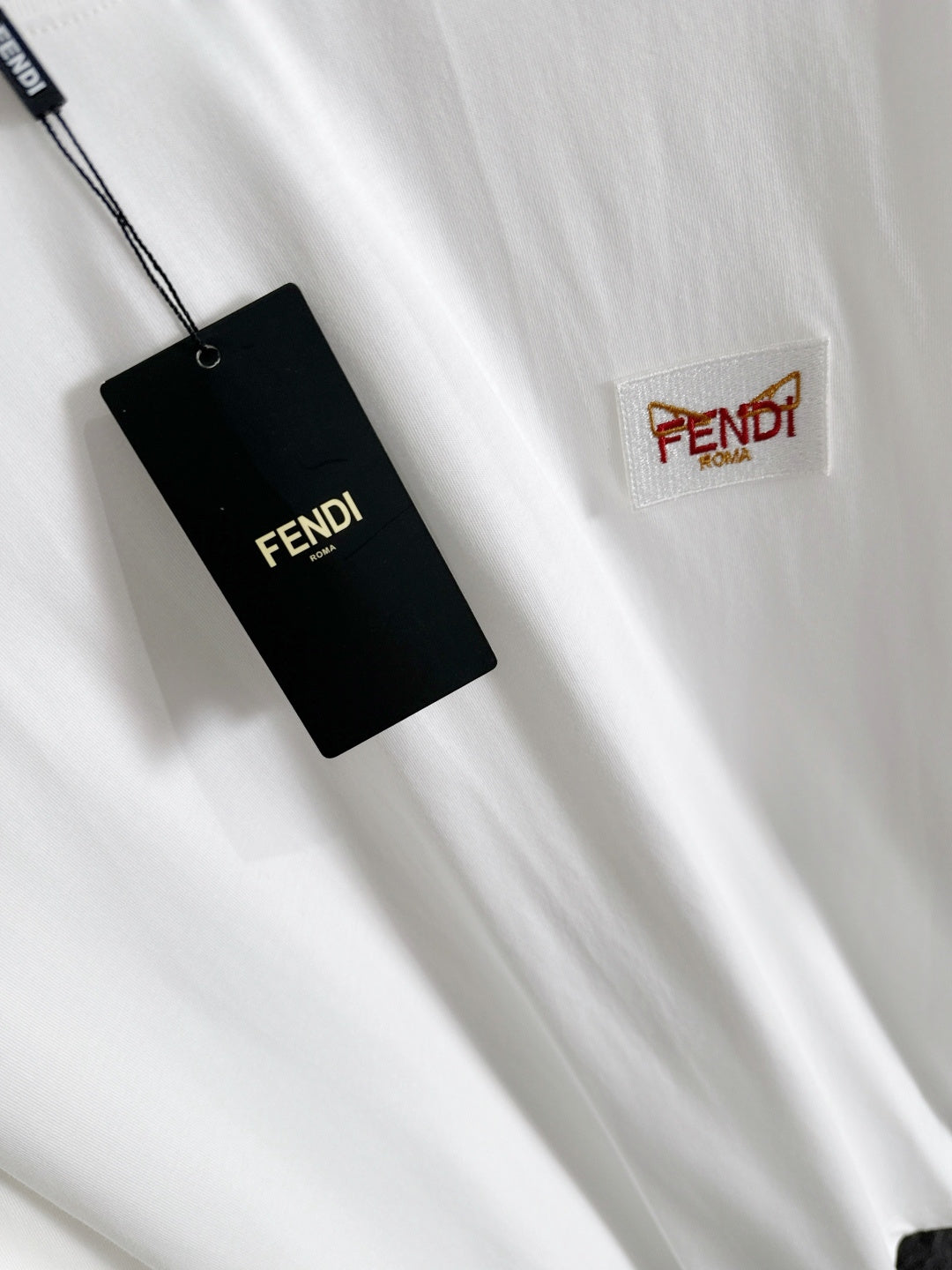 White long-sleeve shirt with FENDI woven label patch and hanging tag