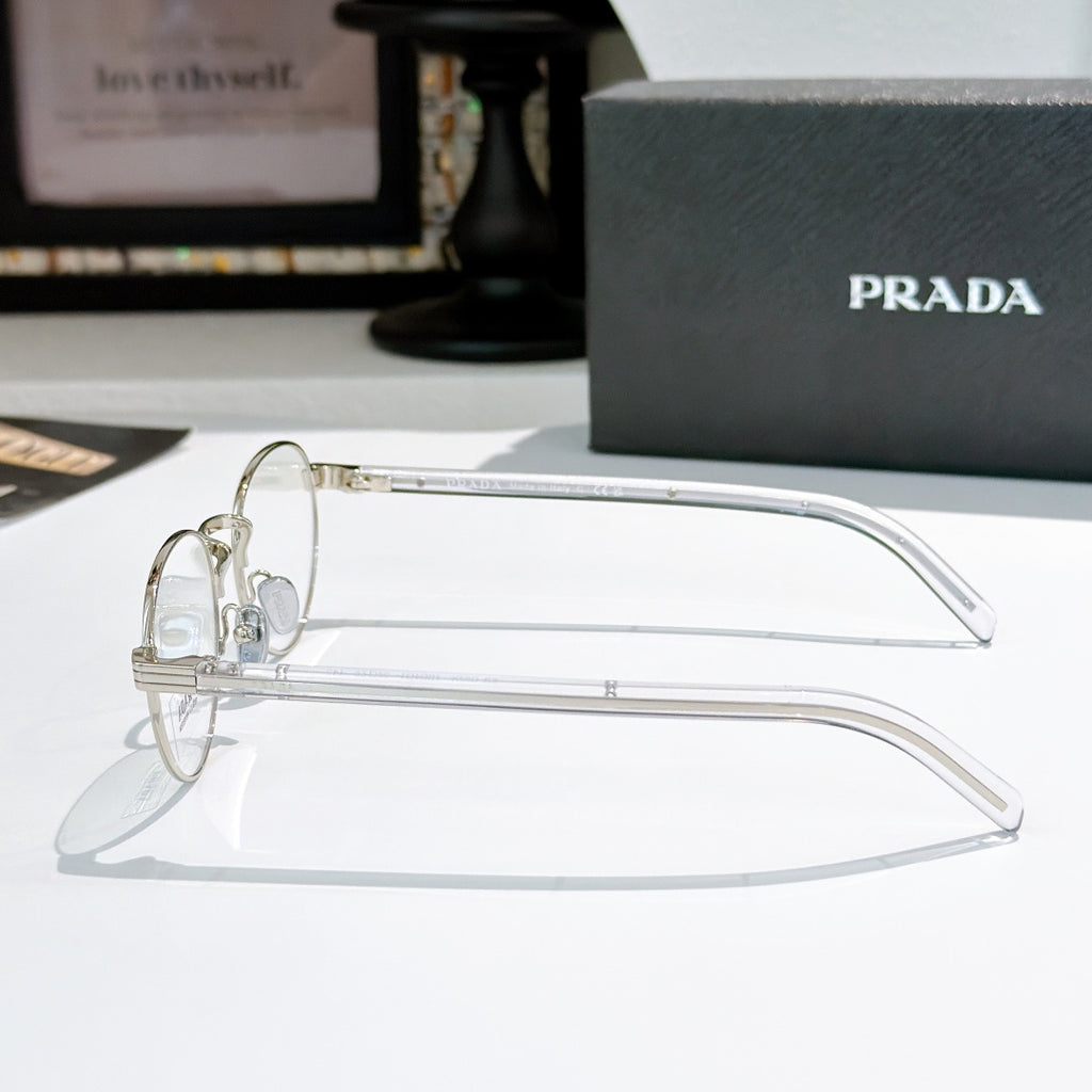 Silver round eyeglasses with clear temple arms and small logo details