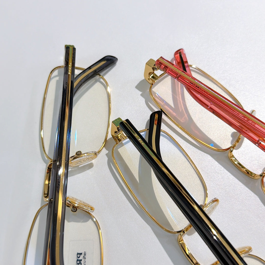 Glasses frames with gold, black, and red striped temple arms
