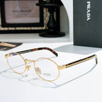 Prada eyeglasses with round gold frames and tortoiseshell temple tips