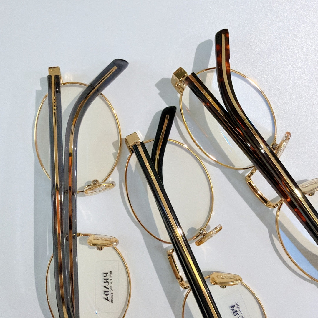 Prada eyeglasses close-up showing round clear frames and striped temples