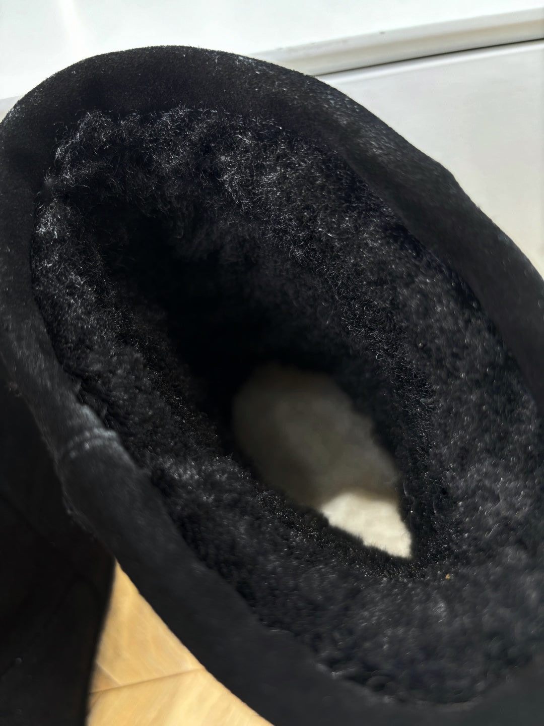 Black suede boot interior, open cuff and soft lining close-up