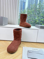 Women’s reddish-brown suede ankle boots, one upright and one resting with logo details