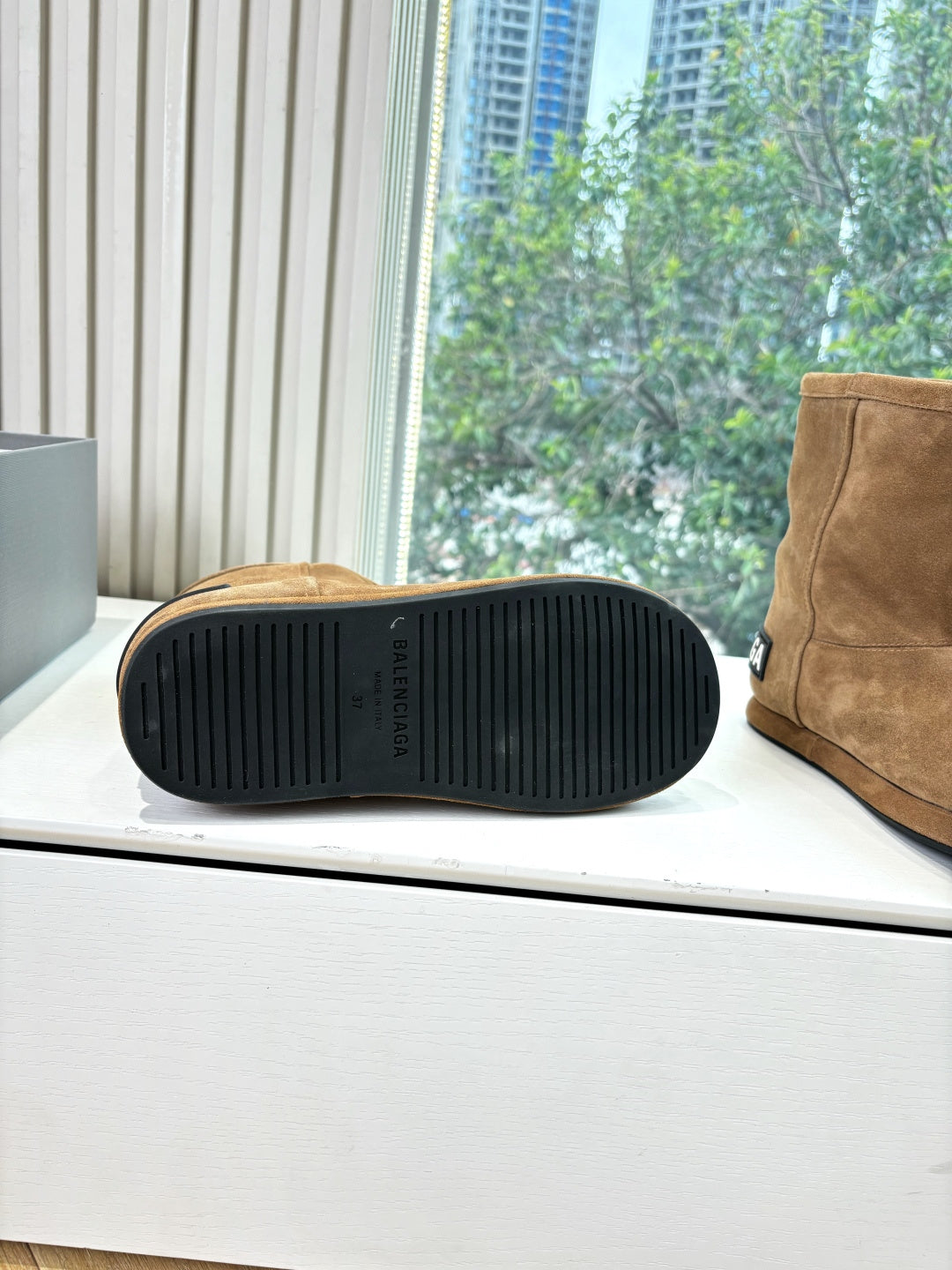 Tan suede ankle boot sole view with black rubber tread and heel