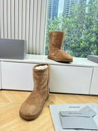 Tan suede ankle boot with plush shearling lining and pull-on shaft