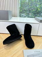 Black suede ankle boots, low stacked heel, side logo, pair on wooden floor