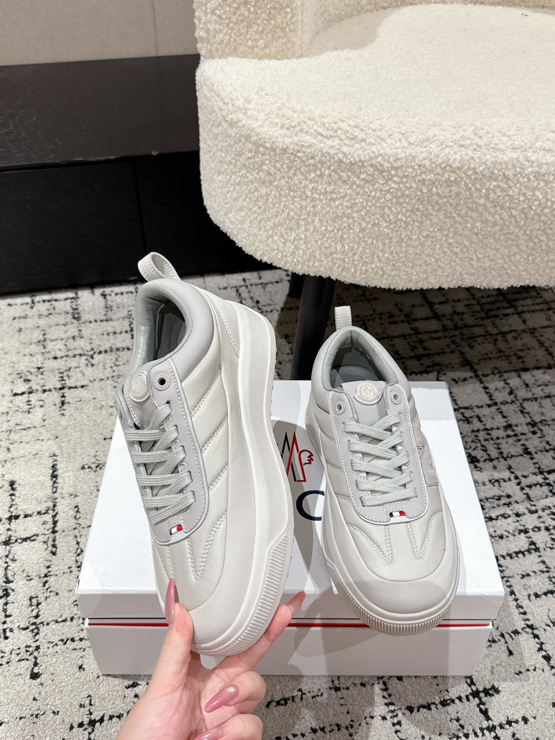 White low-top sneakers, side view with embroidered crest on quarter panel
