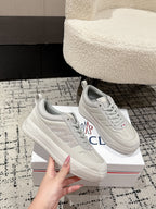White low-top sneakers, angled front view with lace-up eyelets