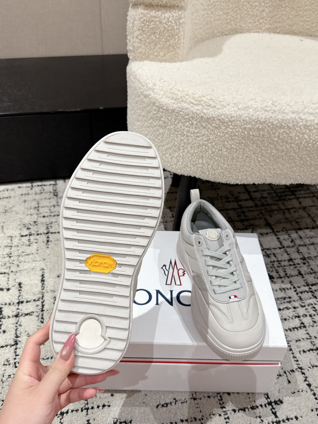 White sneaker outsole with tread pattern and circular logo on heel