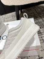 White sneaker side view with stitched panel and Moncler lettering