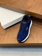 Prada unisex suede sneaker in dark blue, front view with lace-up and white sole