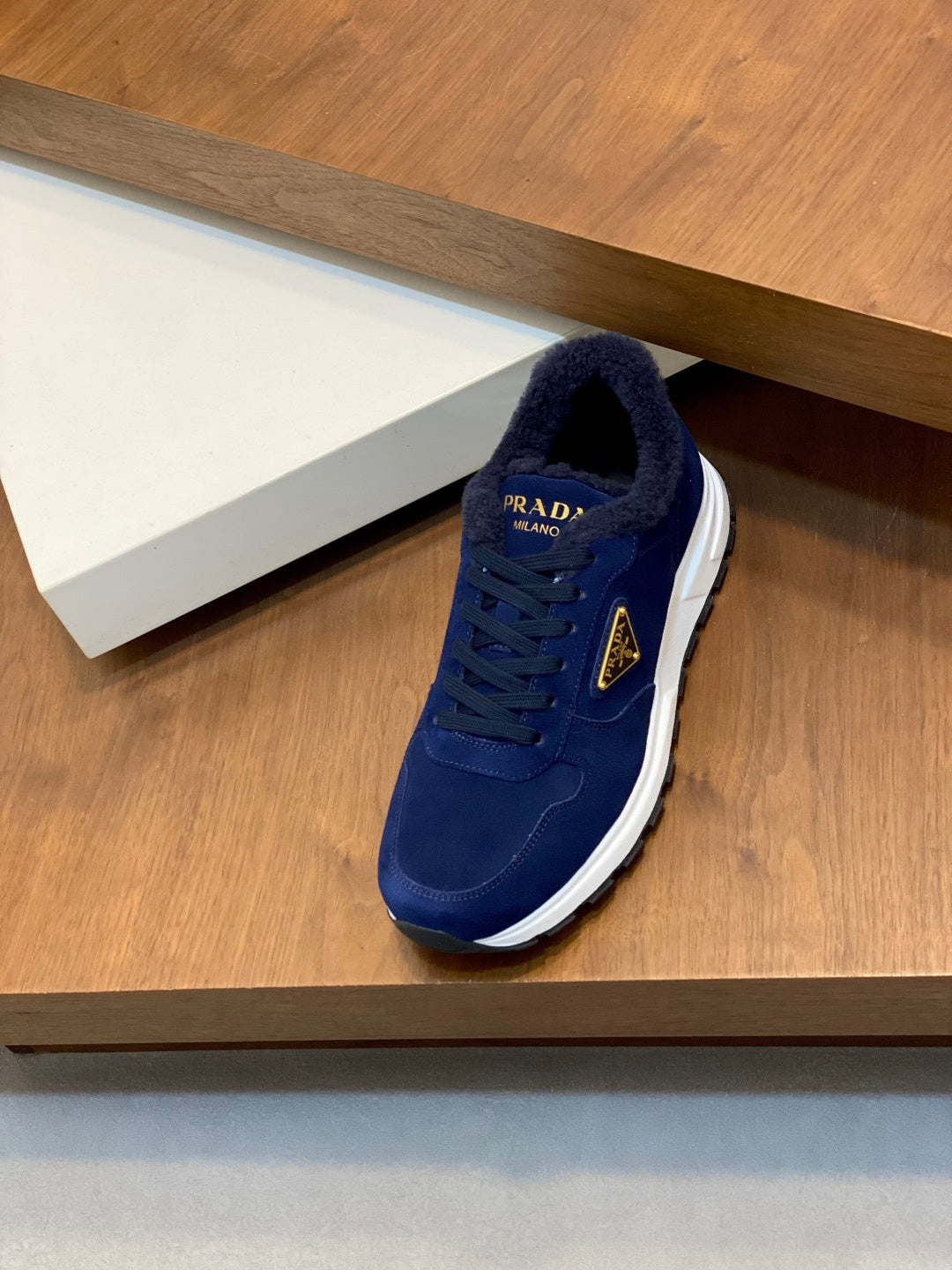 Prada unisex suede sneaker in dark blue, front view with lace-up and white sole