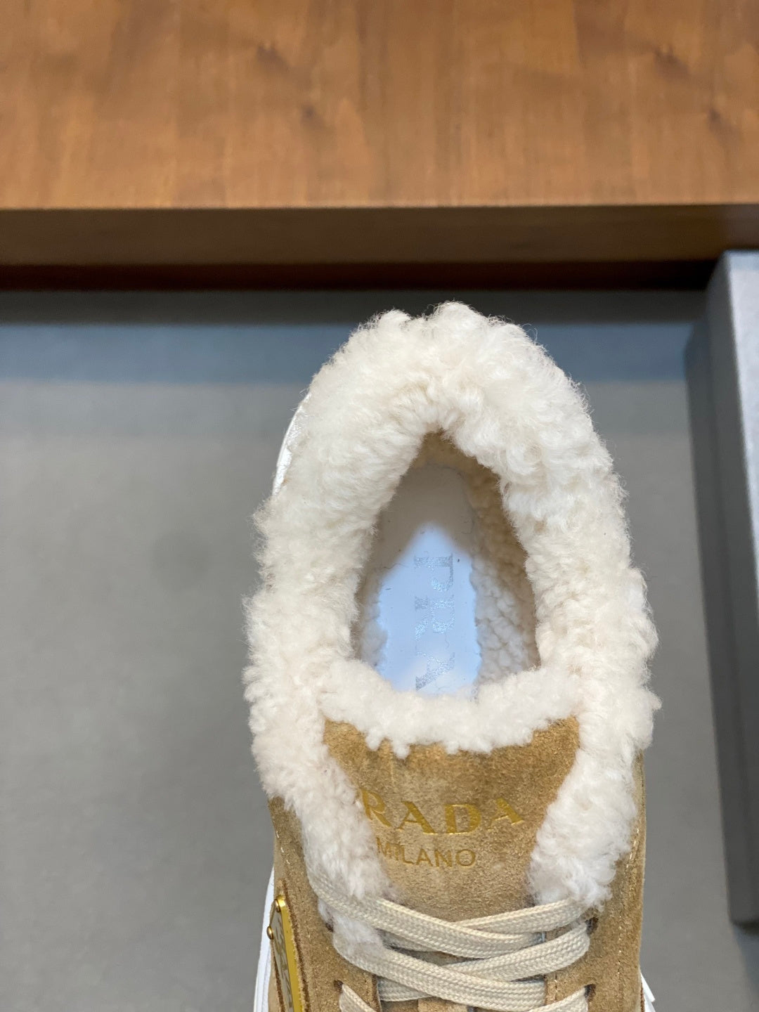Prada unisex suede sneaker tongue with visible logo and white shearling trim