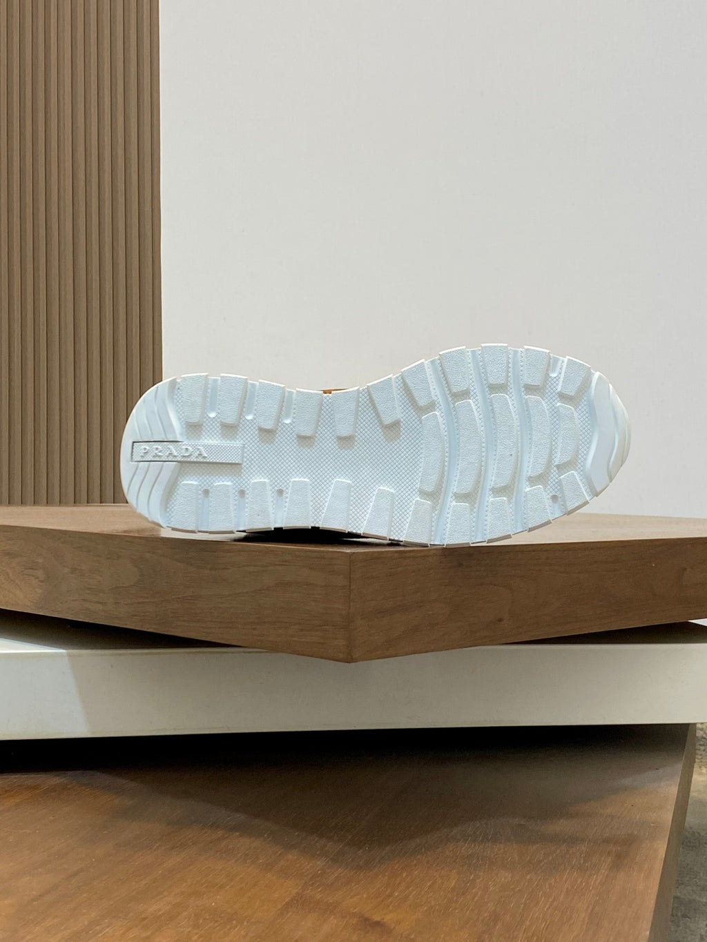 White rubber sneaker outsole with tread, rear view