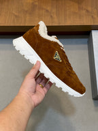 Brown suede lace-up sneaker with shearling collar and white tread sole, logo patch