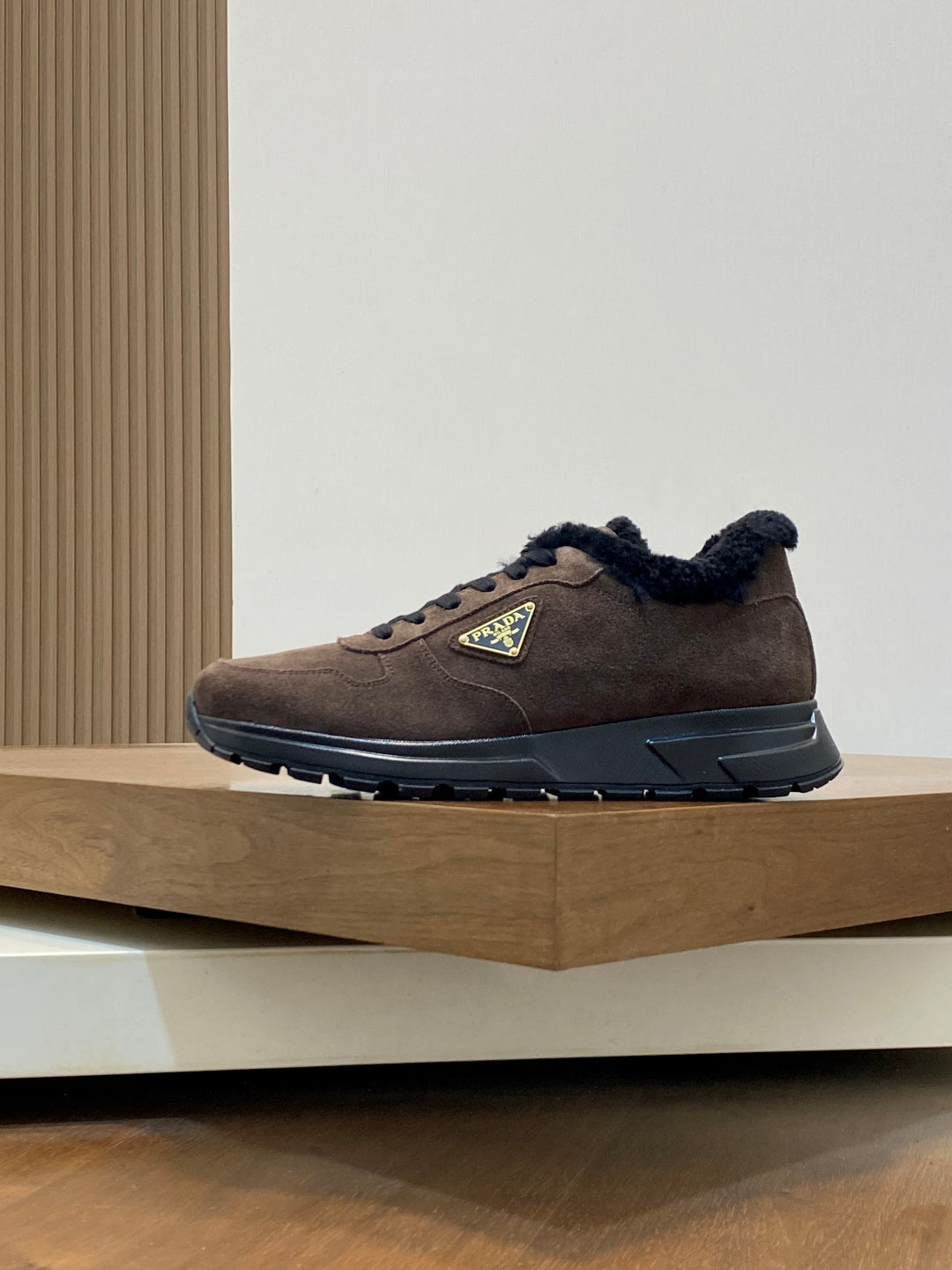 Brown suede Prada sneakers with black shearling collar, lace-up design, rubber sole