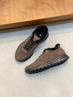 Pair of brown suede Prada sneakers with black fur lining, lace-up front, treaded sole