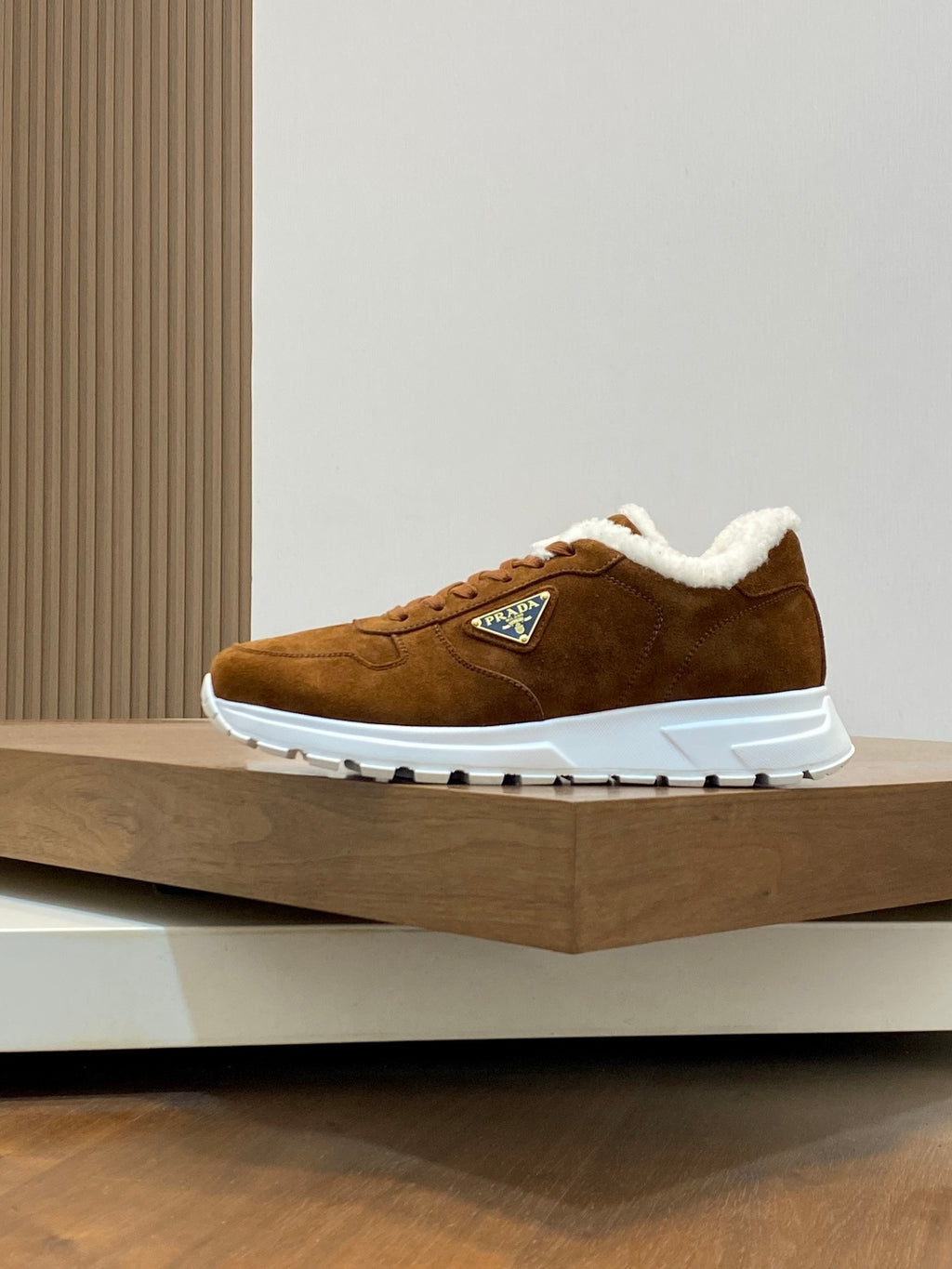 Brown suede lace-up sneaker with white sole and shearling collar, side logo patch