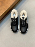 Black Prada lace-up sneakers with white sole and fluffy sherpa collar, front view.