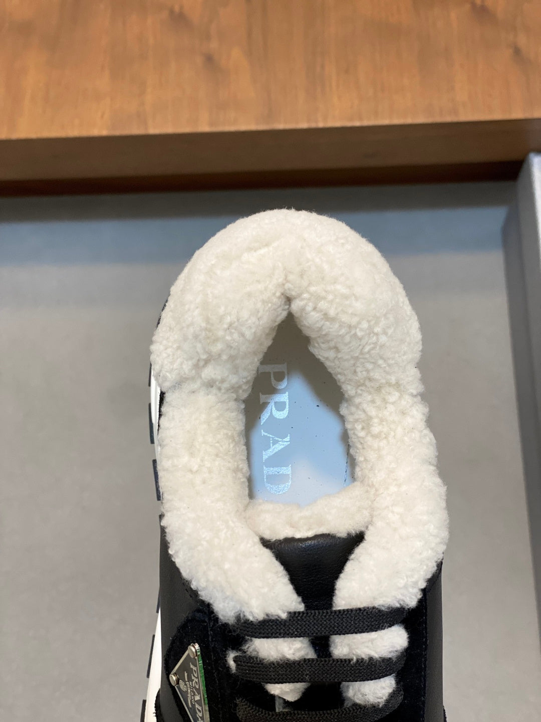 Prada unisex black sneaker detail with sherpa-lined collar and lace-up front