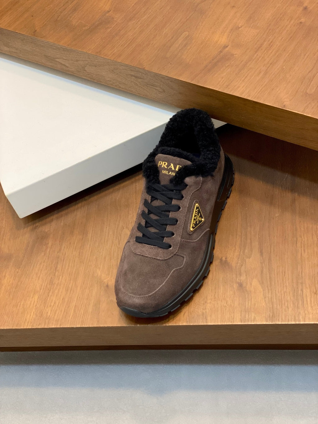 Brown suede Prada sneakers with black faux-fur trim, lace-up vamp, logo on side