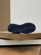 Prada unisex sneakers outsole view, dark rubber tread with raised grip pattern.