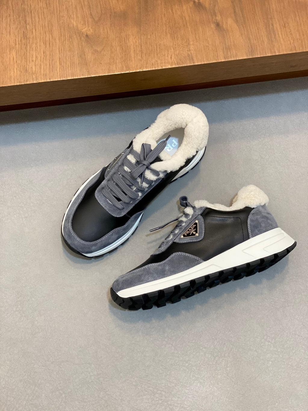 Prada unisex sneakers pair view, dark navy/gray with fleece lining, lace-up, cushioned sole.