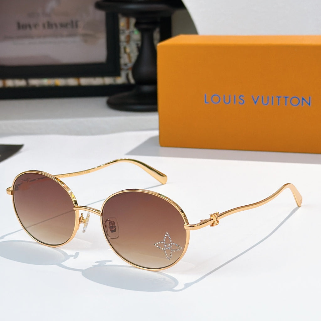 Round sunglasses with gold frame and rose-tinted gradient lenses, rhinestone detail at lens