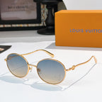 Round sunglasses with gold frame and light blue gradient lenses, rhinestone detail at lens