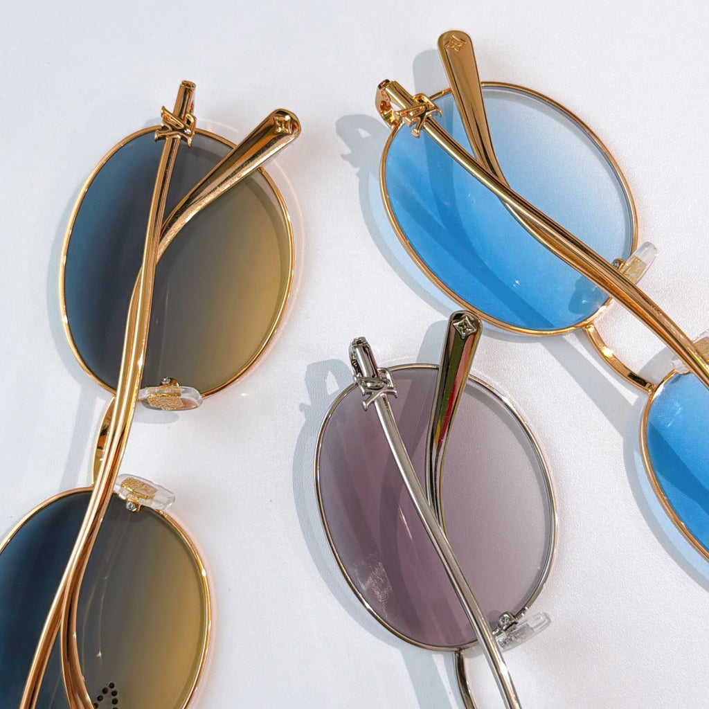 Set of round sunglasses with gold frames and mixed tinted lenses: blue, purple, and amber