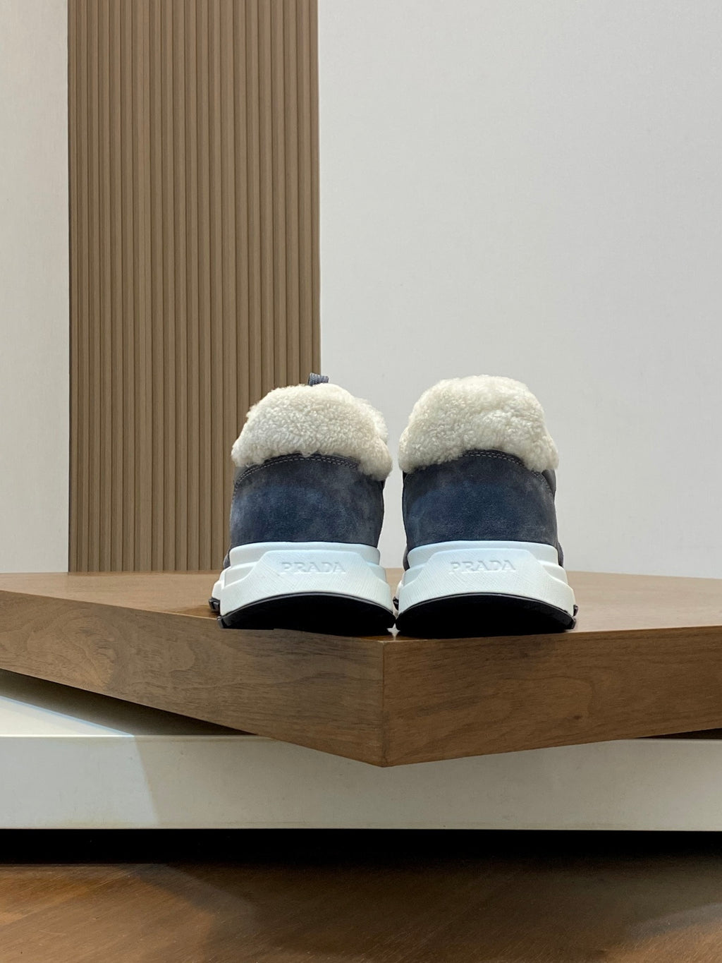 Prada unisex sneakers rear view; dark gray uppers with shearling lining and white soles
