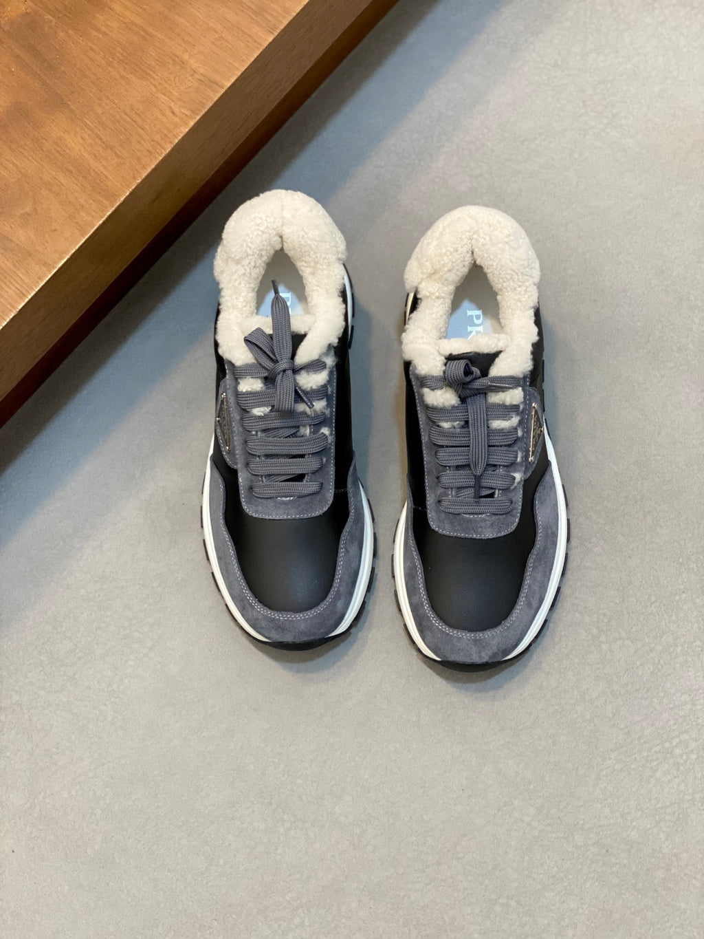Prada unisex sneakers, dark navy/gray leather with fleece-lined collar, lace-up front.