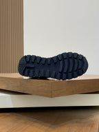 Prada unisex sneaker outsole view: dark blue tread pattern on white-and-blue sole.