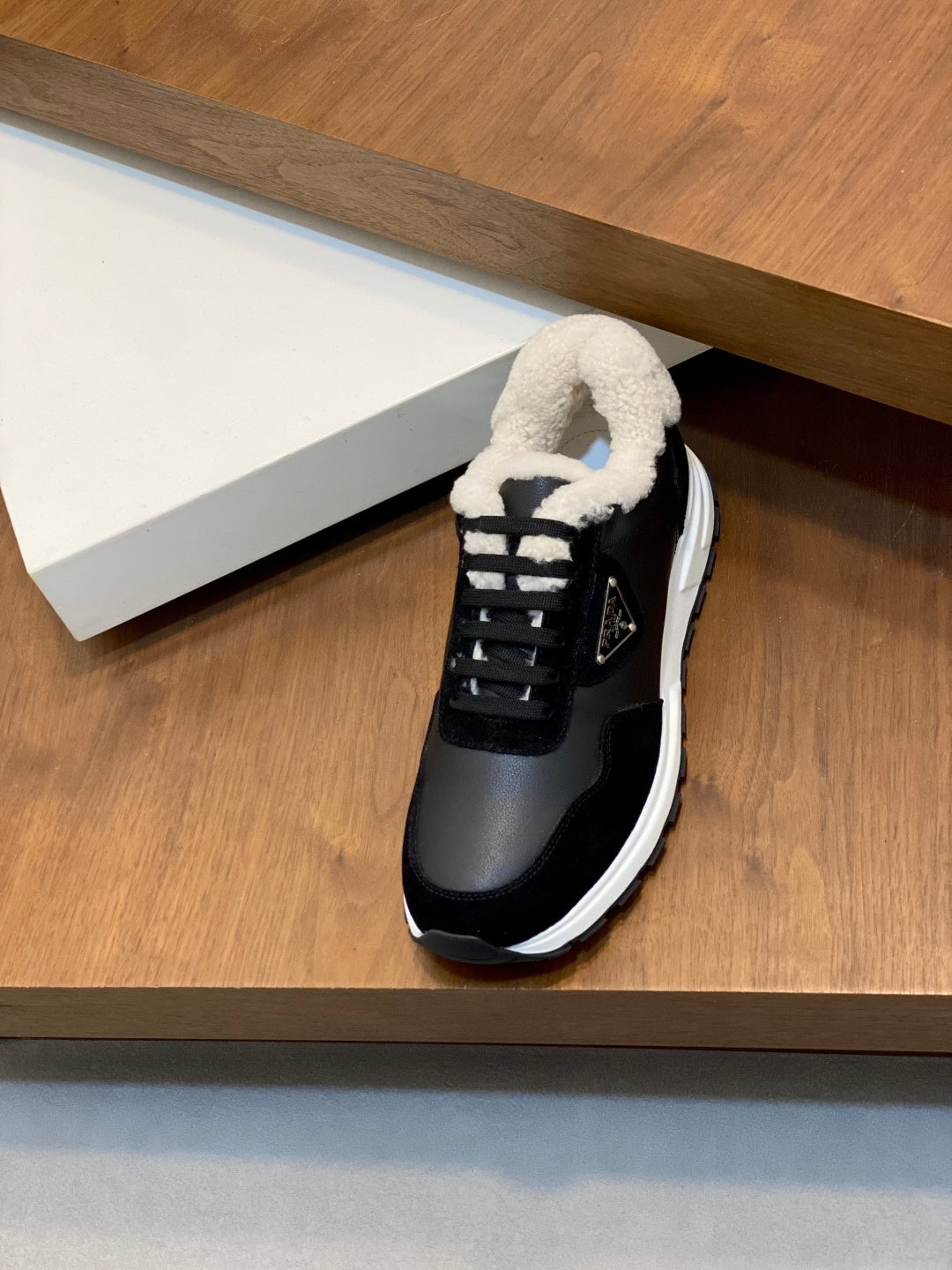 Prada unisex black lace-up sneakers with plush sherpa collar and white outsole