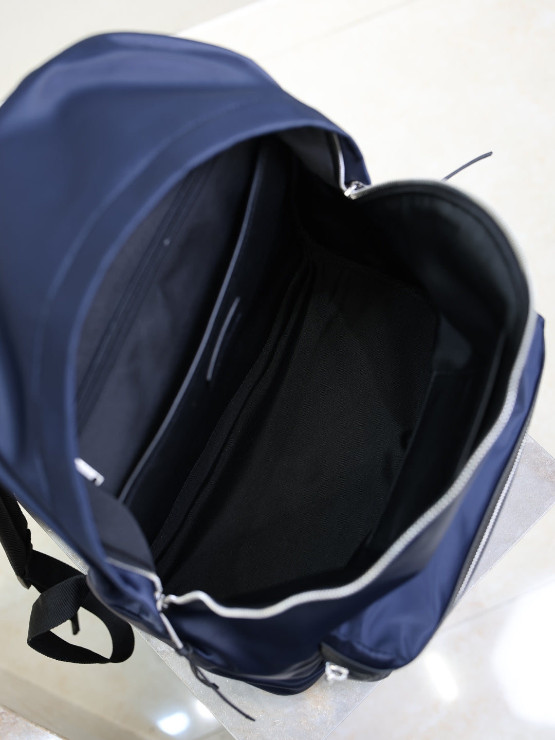 YSL navy backpack open top showing black lined interior