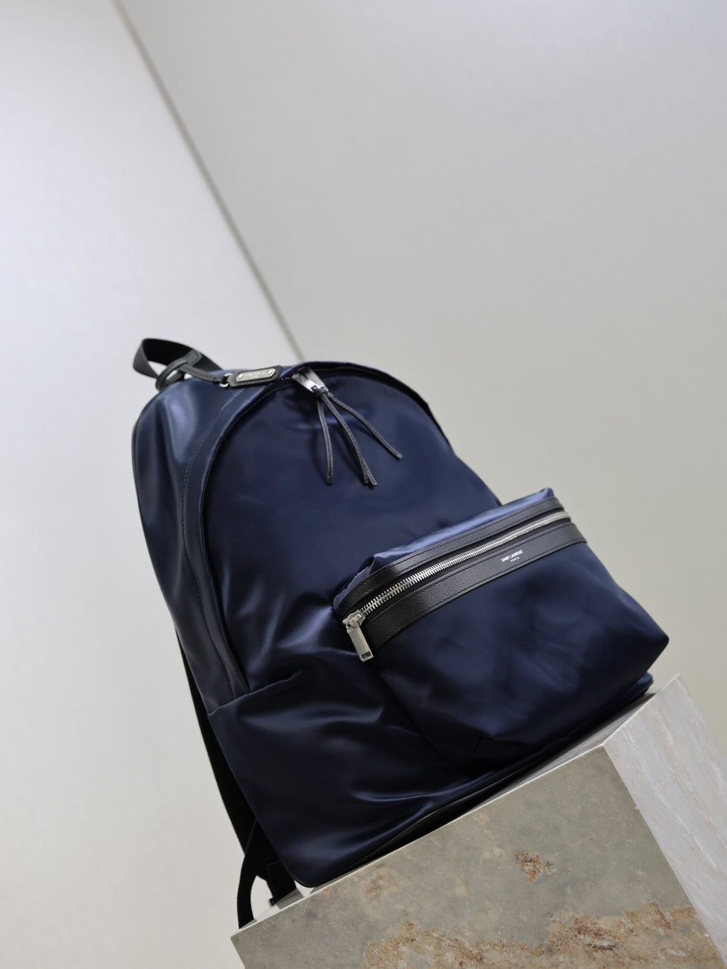 YSL navy backpack with front zip pockets and top carry handle