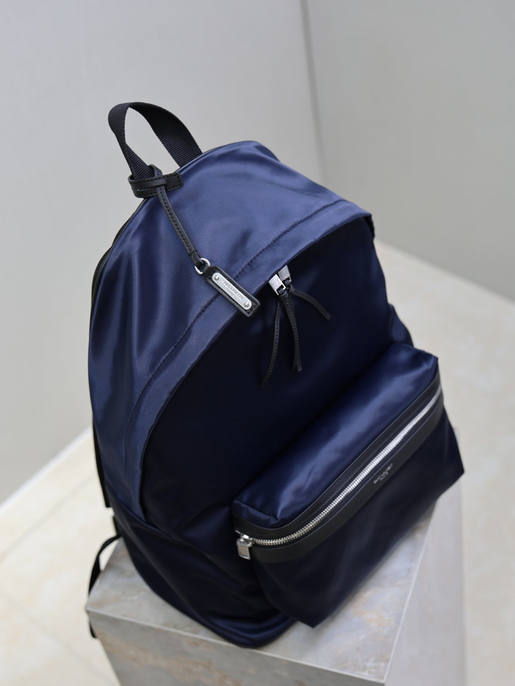 YSL navy backpack with top handle, front zip pocket, and adjustable straps