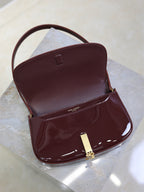 Burgundy patent mini shoulder bag, open flap with gold clasp and small inner pocket