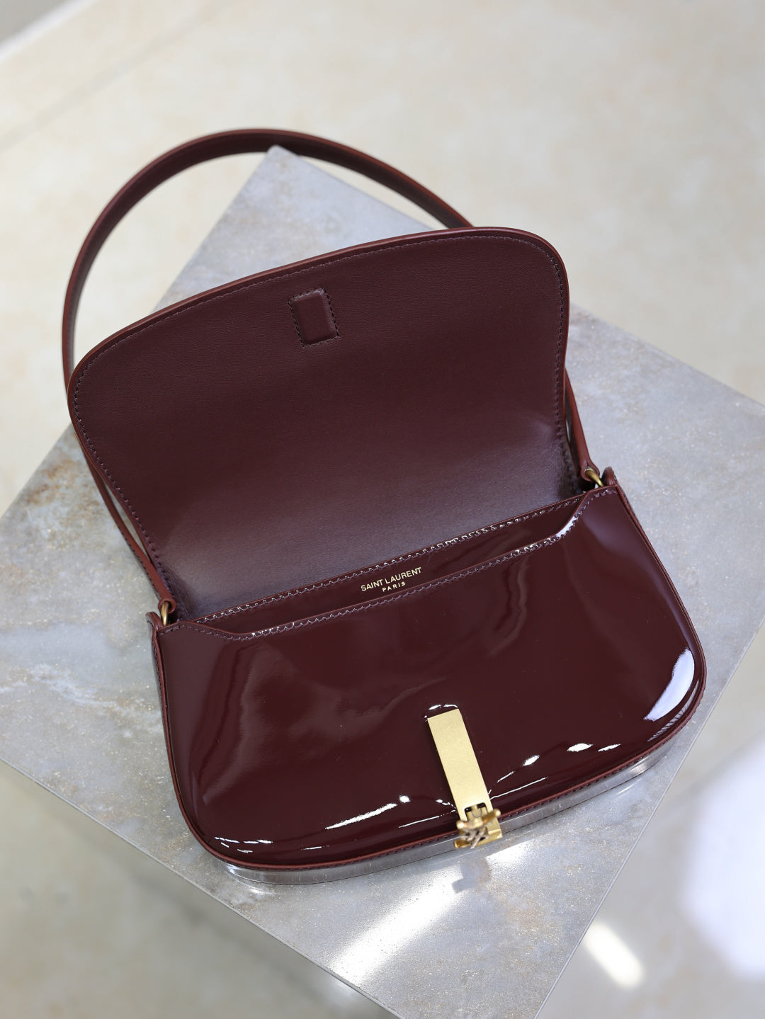 Burgundy patent mini shoulder bag, open flap with gold clasp and small inner pocket