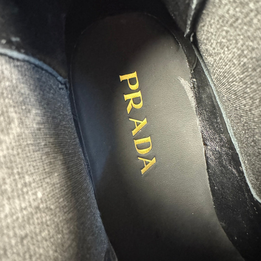 Prada logo on boot insole, yellow and black branding on black leather