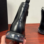 Black leather ankle boot heel pull tab and clear outsole trim.