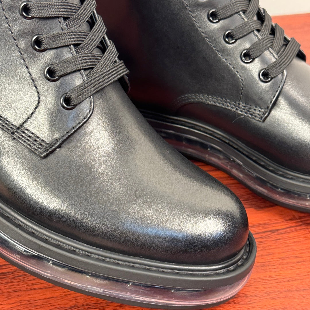 Black leather lace-up ankle boots close-up of laces and stitched toe seam.