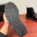 Black rubber outsole of ankle boots with Prada branding and tread pattern.