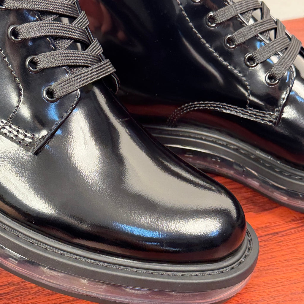 Black lace-up ankle boot close-up with metal eyelets and thick sole