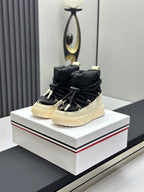 Moncler high-top sneakers with black upper, cream sole, and lace-up closure