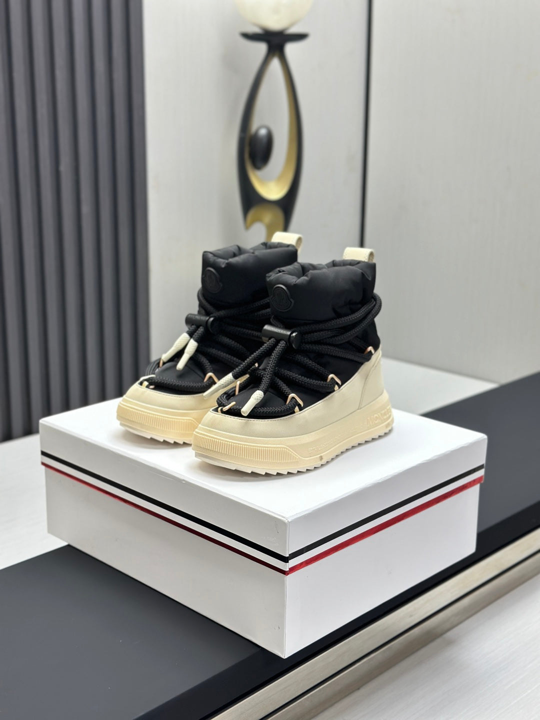 Moncler high-top sneakers with black upper, cream sole, and lace-up closure