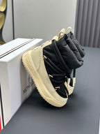 Moncler side view sneakers with black upper, cream midsole, and lace details