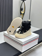 Moncler sneakers shown from outsole, black upper with cream treaded sole